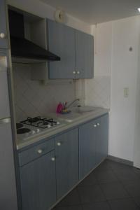 a kitchen with blue cabinets and a stove top oven at Les Stoechades in Hyères