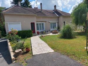 ein Haus mit Garten davor in der Unterkunft Gite 3 étoiles, Maison spacieuse en bord de rivière in Saulgé