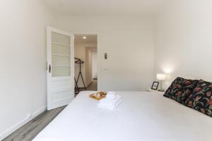 Un dormitorio blanco con una gran cama blanca y una puerta en Belem Boutique Apartments by Homing en Lisboa