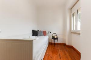 1 dormitorio con cama blanca y ventana en Belem Boutique Apartments by Homing en Lisboa