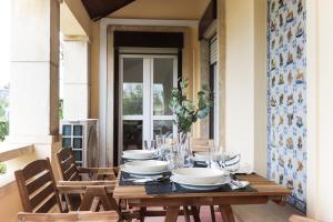 a wooden table with plates and bowls on it on a porch at Nine Horizons Belém in Lisbon