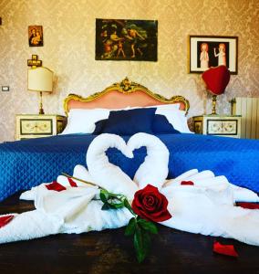 1 dormitorio con 1 cama con 2 cisnes y rosas en Villa dei Marchesi Carrozza, en Santa Teresa di Riva