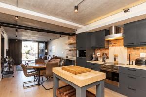 uma cozinha com armários pretos, uma mesa e uma sala de jantar em Docklands Luxury Two Bedroom Apartments em Cidade do Cabo