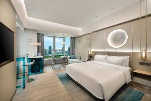 Voodi või voodid majutusasutuse Shenzhen Grand Skylight Garden Hotel toas