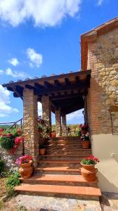 a stone entrance to a building with stairs and flowers at Agriturismo La Casina in Saturnia