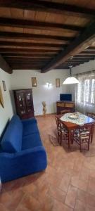 a living room with a blue couch and a table at Agriturismo La Casina in Saturnia