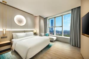 Voodi või voodid majutusasutuse Shenzhen Grand Skylight Garden Hotel toas