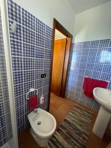 Baño de azulejos azules con aseo y lavamanos en Casale Etna Testa di Moro, 