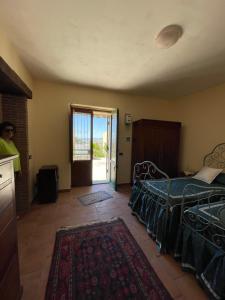 1 dormitorio con 1 cama y puerta corredera de cristal en Casale Etna Testa di Moro, 