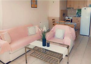 ein Wohnzimmer mit einem rosa Sofa und einem Tisch in der Unterkunft Blue Appartment in Nea Iraklitsa