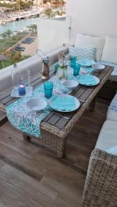 una mesa con platos y gafas azules. en APARTMENT MARINA CALADOR HARBOURVIEW AIR CONDITION POOL GARDEN TERRASSE PORTO CARI spectacular locatio en Cala D'Or