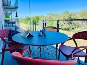 einen blauen Tisch und Stühle auf einem Balkon mit einem Buch in der Unterkunft Haus Zudar / Prora in Binz