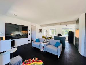 ein Wohnzimmer mit 2 Stühlen und einem Flachbild-TV in der Unterkunft Haus Zudar / Prora in Binz