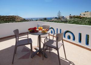 une table avec une assiette de nourriture sur un balcon dans l'établissement Studios Eftihia, à Keratokampos