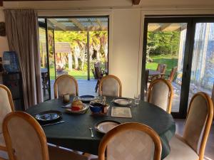 a dining room table with a black table and chairs at Tekoa Lodge Raurimu in Raurimu Spiral