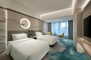 Voodi või voodid majutusasutuse Shenzhen Grand Skylight Garden Hotel toas