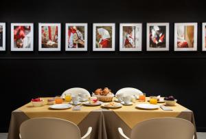 a table with food and pictures on a wall at Hotel San Teodoro in San Teodoro