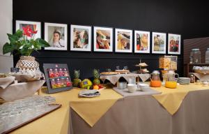 a table with food on it with pictures on the wall at Hotel San Teodoro in San Teodoro