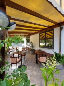 a patio with tables and chairs and windows at Maison des Roses in Cesenatico