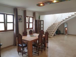 une salle à manger avec une table, des chaises et un escalier dans l'établissement Villa Valeria, à Divšići