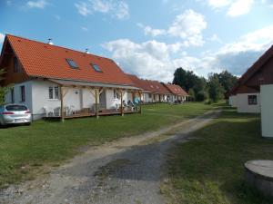 a row of houses with a car parked next to them at Komplex Apartmánů Jestřábí in Černá v Pošumaví