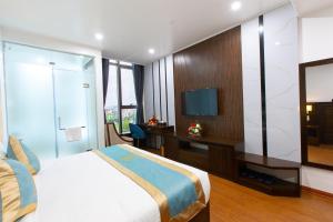 a bedroom with a bed and a desk and a television at SALA HOTEL MÓNG CÁI in Móng Cái