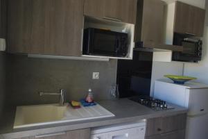 a kitchen with a sink and a microwave at Les Stoechades in Hyères