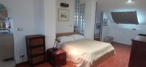 a bedroom with a bed with white sheets and a window at Appartamento mansardato iPatrizi in Moncalieri