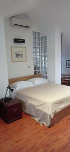 Appartamento mansardato iPatrizi في مونكالييري: غرفة نوم مع سرير وحقيبة على الأرض