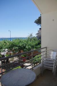 a balcony with a table and chairs and the ocean at Les Stoechades in Hyères