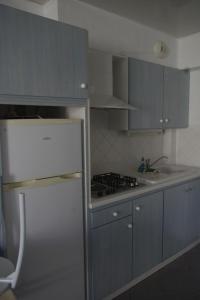 a kitchen with blue cabinets and a white refrigerator at Les Stoechades in Hyères