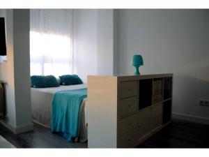 sypialnia z łóżkiem, komodą i oknem w obiekcie Blue Loft Atocha w Madrycie