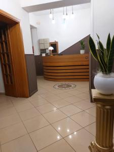 a lobby with a desk with a potted plant at Maison des Roses in Cesenatico +32 photos