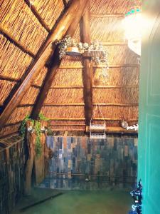 a swimming pool in a straw roofed building at Lone Wolf's Lair in Parys