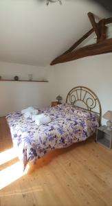 1 dormitorio con 1 cama con edredón morado en cheztitoine, en Pouzauges