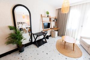 ein Wohnzimmer mit einem Spiegel und einem Tisch in der Unterkunft ELYSIUM GARDEN HOTEL in Bozyazı
