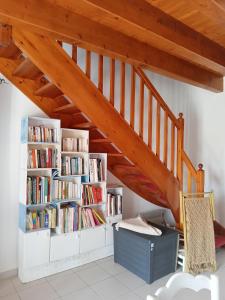 a room with a staircase with bookshelves at Oléron côte ouest, 3 étoiles in La Cotinière
