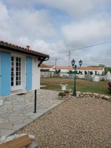 ein Haus mit einer blauen Tür und einem Straßenlicht in der Unterkunft Oléron côte ouest, 3 étoiles in La Cotinière