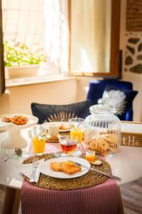 una mesa con platos de comida y vasos de zumo de naranja en Domu Manca en Torpè