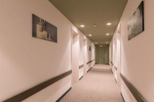 einen Korridor eines Krankenhausflurs mit weißen Wänden in der Unterkunft Century Hotel Antwerpen Centrum in Antwerpen