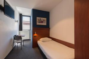a bedroom with a bed and a chair at Century Hotel Antwerpen Centrum in Antwerp