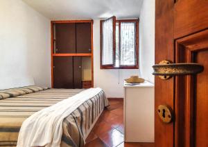 a bedroom with a bed and a window and a door at Trilocale La Pineta Quiet garden in Marina di Campo