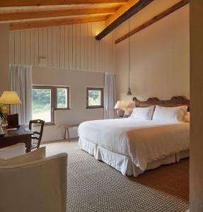 a bedroom with a bed and a desk and windows at OAR Cottage in Durango