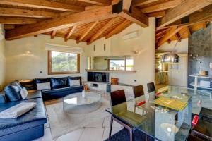 een woonkamer met een blauwe bank en een tafel bij Villa Oleander in Manerba del Garda