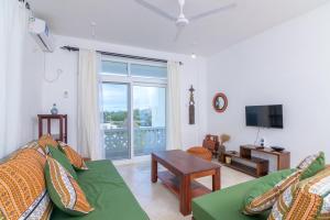 uma sala de estar com um sofá e uma televisão em Bali House em Malindi