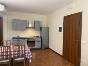 a kitchen with a table and a refrigerator at Residenza Cipressi e Olivi in Verona