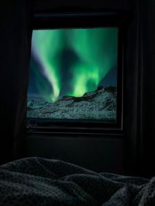 una ventana con vistas a la aurora boreal en Segla Guesthouse - Lovely sea view en Fjordgård