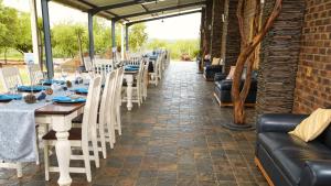 a row of tables and chairs in a brick building at Kareespruit Game Ranch & Guest House in Zeerust