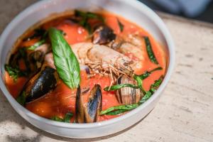 a bowl of soup with seafood and vegetables on a table at Kassandra Boutique Hotel in Oludeniz