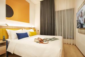 a hotel room with a bed with shoes on it at Citadines Connect City Centre Singapore in Singapore